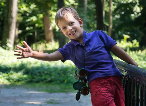 Niño en puente estrechando su mano con prismáticos —  Fotos de Stock
