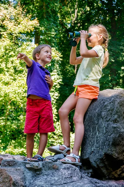 Niños jugando al aire libre y divirtiéndose con prismáticos — Foto de Stock