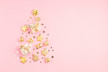 Noel orgazmları ve hediye kutuları pembe arka planda Noel ağacı şeklinde dizilmiş. Kış tatili tebrik kartı, fotokopi alanı olan davetiye. Düz uzan, yukarıdan bak.