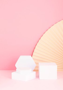 Podyum, stand, ürün sunumu platformu. Kağıt vantilatörlerden oluşan soyut bir arka plan. Markalaşma ve paketleme sunumu için model