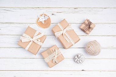 Noel süsleri ve hediye kutuları beyaz arka planda organik el sanatları kağıdına sarılı, düz, üst manzara, kopyalama alanı. Kış tatili, xmas tebrik kartı.