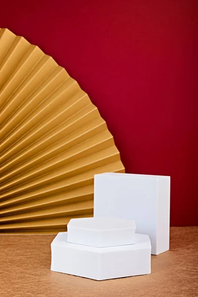 Podium, stand, platform for product presentation.Abstract background made of paper fans and Christmas decoration. Mockup for branding and packaging presentation