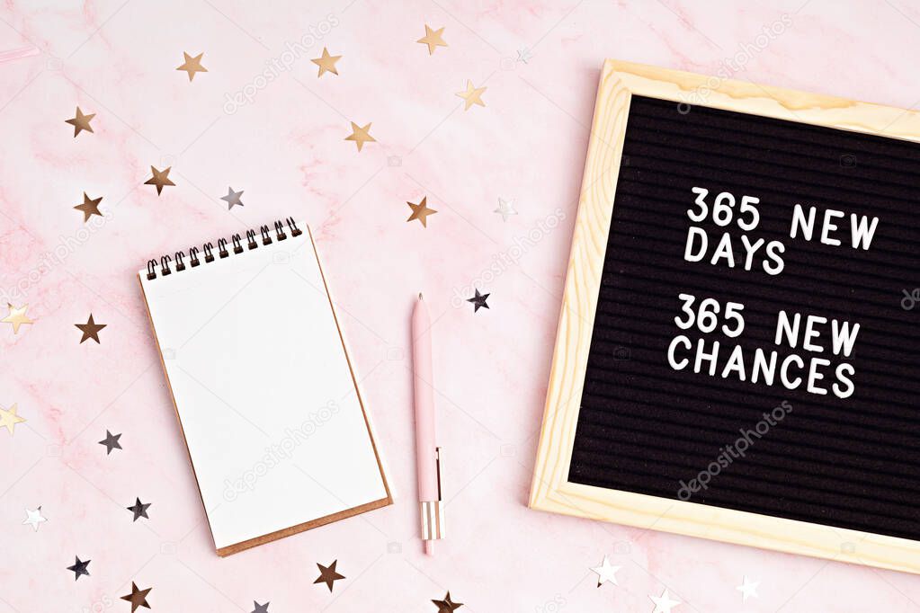 365 new days, 365 new chances. Letter board with motivational quote with notepad , pen and stars confetti. New years resolutions mockup