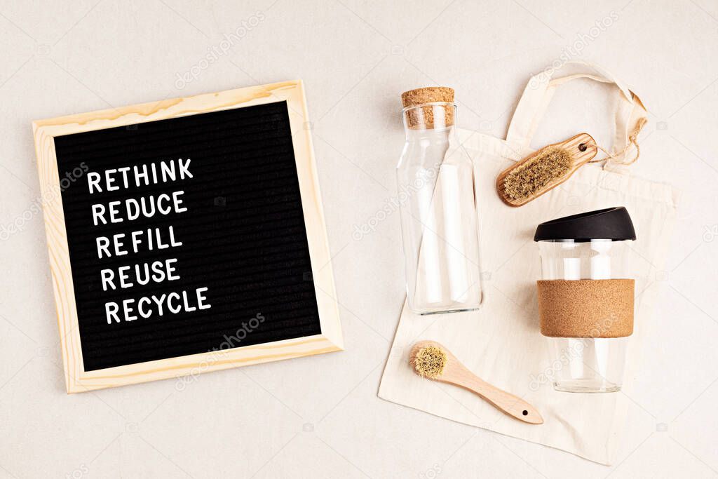 Rethink, reduce, refill, reuse, recycle. Black letter box with eco friendly shopping bag, bottle, coffee cup and brushes on white background. Zero waste sustainable lifestyle. Plastic free concept. Flatlay, top view