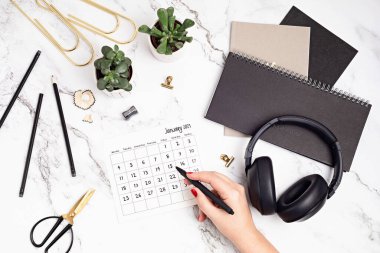 Ocak 2021 takvimi ve ofis malzemeleriyle dolu bir masaüstü. Ev ofisi, sosyal medya blogu, program, planlama konsepti. Flatlay, üst görünüm