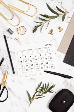 Ocak ayı ve ofis malzemeleri için takvimi olan bir masaüstü. Ev ofisi, sosyal medya blogu, program, planlama konsepti. Düz yatış, üst görünüm