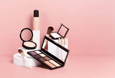 Makyaj ürünleri beyaz podyumlarda pembe renkli arka planda sergileniyordu. Markalaşma ve paketleme sunumu için model