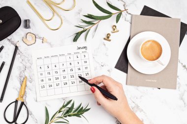 Ocak ayı ve ofis malzemeleri için takvimi olan bir masaüstü. Ev ofisi, sosyal medya blogu, program, planlama konsepti. Düz yatış, üst görünüm