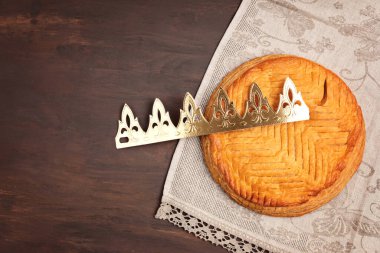 Kral keki ya da Fransızcada galette des rois. Altın kaplama taç ve küçük tılsımlı geleneksel tezahür turtası. Üst manzara, düz uzanma