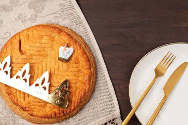 Kral keki ya da Fransızcada galette des rois. Altın kaplama taç ve küçük tılsımlı geleneksel tezahür turtası. Üst manzara, düz uzanma