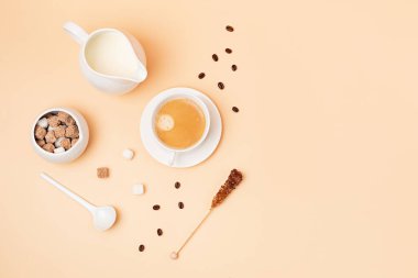 Sabah kahvesi, şeker ve sütle yatıyordu. Bej arka planda fotokopi alanı olan minimum kompozisyon. Markalaşma kavramı