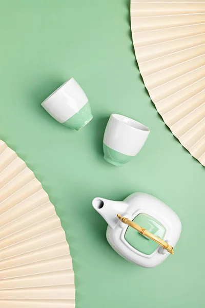 パステルカラーのカップ付きの白いセラミックティーポット 環境に優しいオーガニックブランドのコンセプト ブランドのモックアップ 平面図上面図 — ストック写真