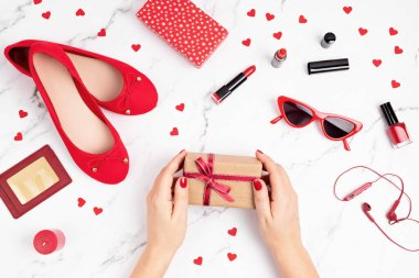 Elinde hediye kutusu, elinde kırmızı aksesuarları olan bir kadınla yatıyordu. Anneler Günü 'nde, Aziz Valentin' in hediye konsepti. Üst görünüm