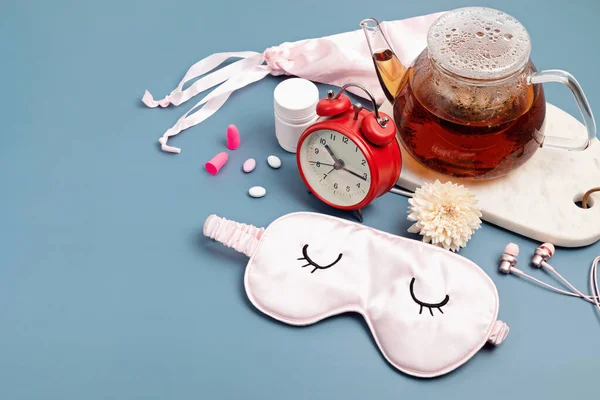 Reloj despertador clásico, máscara para dormir, tetera sobre fondo azul pastel. Concepto mínimo de descanso, calidad del sueño, buenas noches, insomnio, relajación —  Fotos de Stock