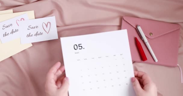 여성은 달력에 날짜를 표시 한다. 날짜 카드와 봉투를 아껴 두 세요. 결혼 계획, 초대 개념 — 비디오