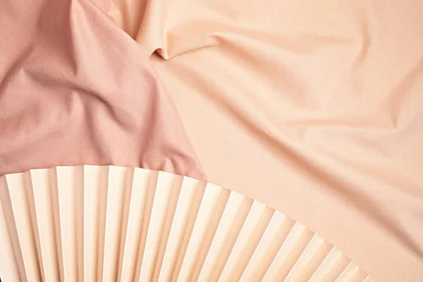 Fundo de tecido rosa e bege com ventilador de papel — Fotografia de Stock