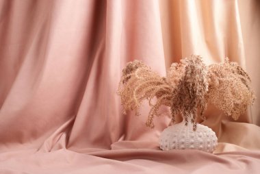 Pembe ve bej renkli arka planda kurutulmuş doğal otlar.