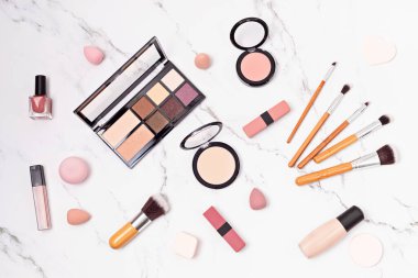 Profesyonel dekoratif kozmetik setleri ve makyaj araçlarıyla düz yatıyordu..