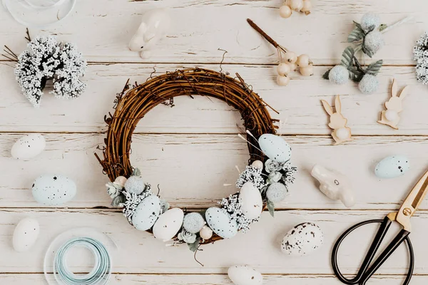 Paskalya yumurtaları ve doğal elementlerle el yapımı ev dekorasyonu çelengi. Düz yatış, üst görünüm yaratıcılık zanaatı kavramı