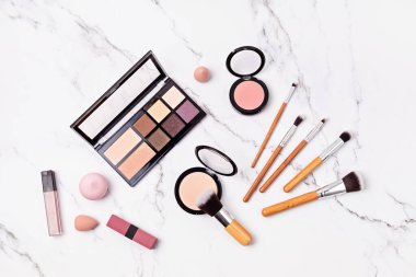 Profesyonel dekoratif kozmetik setleri ve makyaj araçlarıyla düz yatıyordu..