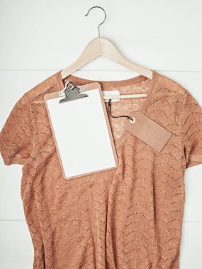 İkinci el kıyafet fikri. Dairesel fshion, çevre dostu sürdürülebilir alışveriş, dükkan konsepti. Etiket modeliyle kazağın üstünü göster.