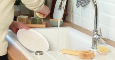 Kadın bulaşıkları çevre dostu zehirli olmayan ürünlerle yıkıyor. Sürdürülebilir yaşam tarzı, sıfır atık temizleme