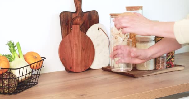 Frau stellt Nudeln aus Baumwolltasche in Glasgefäße. Mehrwegbeutel für Produkte, Null-Abfall-Konzept — Stockvideo