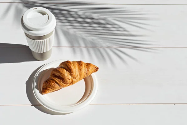 Café caliente sobre la marcha y croissants para el desayuno. Taza para llevar biodegradable y reutilizable — Foto de Stock