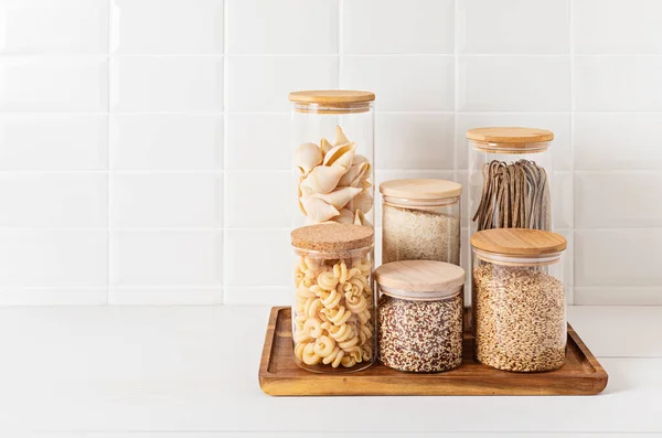 Assortment of grains, cereals and pasta in glass jars on wooden table. Zero waste kitchen storage — Stock Photo, Image