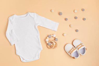 Çevre dostu bebek aksesuarlarıyla organik pamuktan yapılmış beyaz bebek tulumu.