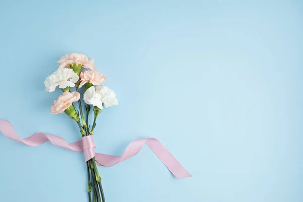 青の背景にピンクのカーネーションの花の花束。聖バレンタイン母の日のアイデア — ストック写真