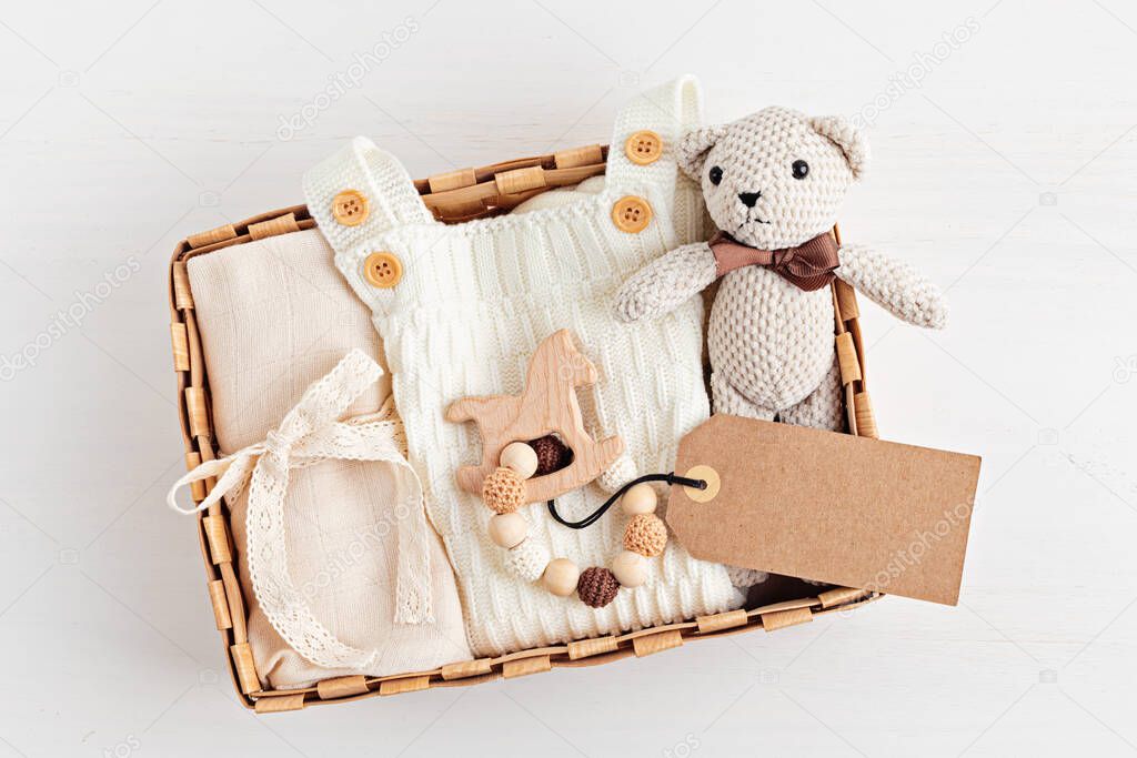 Gift basket with gender neutral baby garment and accessories. Care box of organic newborn cotton clothes