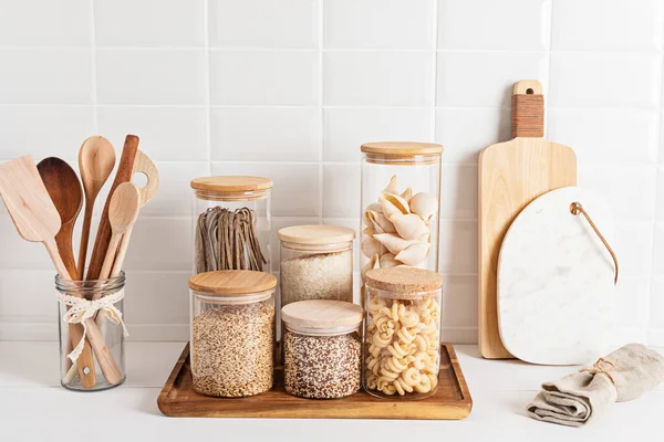 Assortment of cereals and pasta in glass jars and woden kitchen utensils. Zero waste idea — Stock Photo, Image