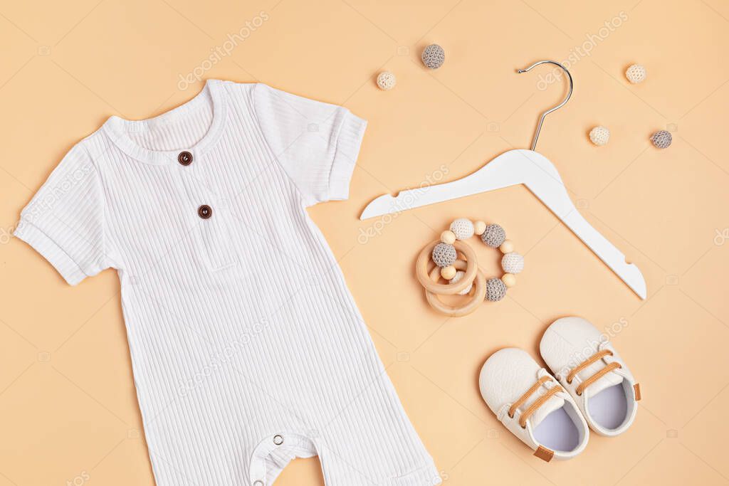 Mockup of white infant bodysuit made of organic cotton with eco friendly baby accessories
