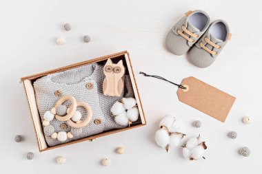 Cinsiyet ayrımı olmayan bebek kıyafetleri ve aksesuarlarıyla hediye sepeti. Yeni doğmuş organik pamuklu giysiler, moda, marka, küçük işletme fikri. Düz yatış, üst görünüm