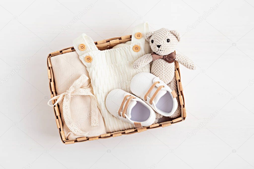 Gift basket with gender neutral baby garment and accessories. Care box of organic newborn cotton clothes, fashion, branding, small business idea. Flat lay, top view