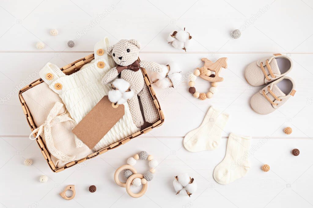 Gift basket with gender neutral baby garment and accessories. Care box of organic newborn cotton clothes