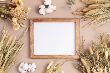 Kuru çiçekler, bitkiler ve ahşap çerçeve.