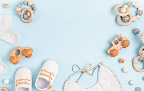 Sapatos de bebê, babador e teether no fundo pastel. Acessórios para recém-nascidos orgânicos — Fotografia de Stock