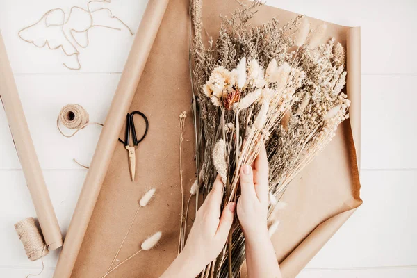 Blomsterhandlare komponera bukett med torra blommor och örter — Stockfoto