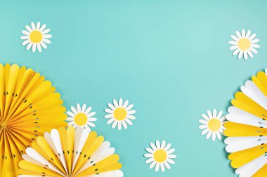 Mavi pastel arka planda sarı kağıt çemberli fanlar olan şenlikli parti geçmişi. Festival, doğum günü, bebek partisi dekorasyonu. Üst görünüm, düz görünüm, kopyalama alanı