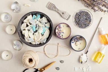 Eski mum artıklarından yapılmış el yapımı aroma mumları için malzemeler ve aletler. Balmumu, temel yağlar, filizler, tencereler. El işi hobisi, küçük işletme, sanatsal ürünler konsepti