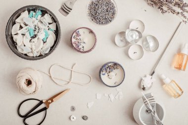Eski mum artıklarından yapılmış el yapımı aroma mumları için malzemeler ve aletler. Balmumu, temel yağlar, filizler, tencereler. El işi hobisi, küçük işletme, sanatsal ürünler konsepti