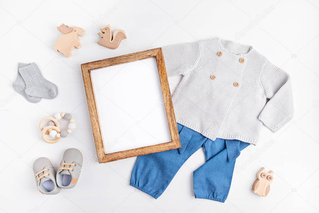 Gender neutral baby garment and accessories and empty frame mockup. Organic cotton clothes