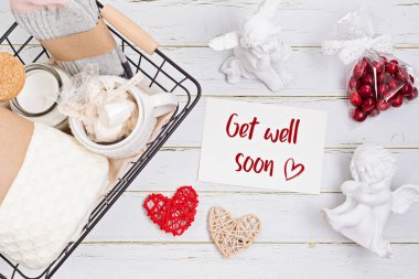 Bakım paketi hazırlanıyor, çabuk iyileş. Sıcak çoraplar, yün örtü, aroma mumu.