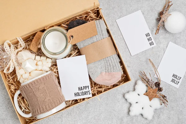 Preparación de paquete de cuidado, caja de regalo de temporada con taza, vela, calcetines de lana y adorno de Navidad — Foto de Stock