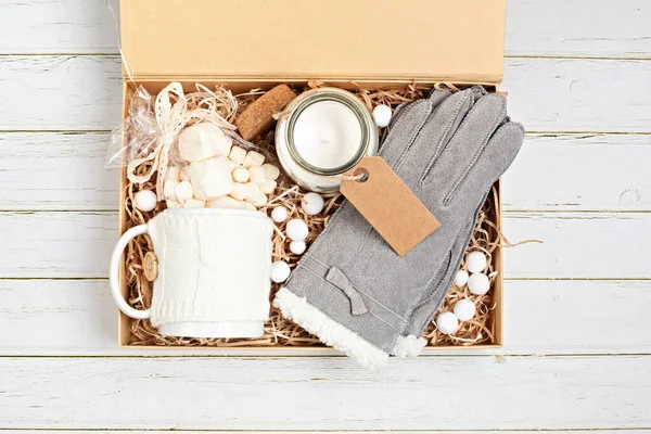 Preparación de paquete de cuidado, caja de regalo de temporada con taza, vela, guantes calientes y adorno de Navidad — Foto de Stock