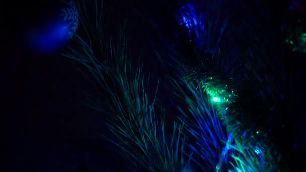 Sihir, geceleri parlayan Noel ağacı ışıklarını kapatır. Süslemeleri ve mavi ve kırmızı ışıklandırması olan yeni yıl ağacı. — Stok video