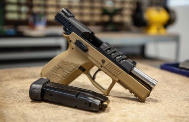 Masada modern siyah-kahverengi travmatik tabanca var. Nefsi müdafaa için dolu olmayan silah güvenli durumda..