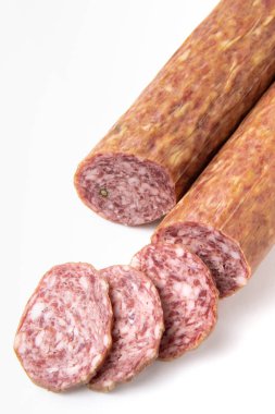 Beyaz bir tabakta dilimlenmiş kurutulmuş sosis. Elit et ürünü..